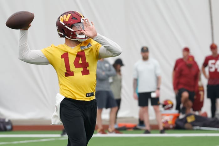 Sam Howell brings his arm back to throw the football at camp